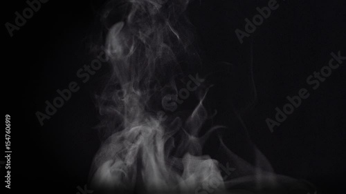 White natural rising steam from food or hot drink isolated on a black background.