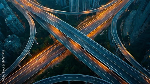 Aerial view of highway interchange at night with glowing streetlights and smooth city traffic flow