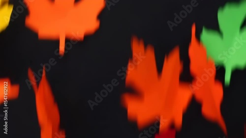 Vibrant Paper Leaves Dance on Black, Autumn Abstract.