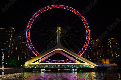 Night view of the Tianjin Eye ferris wheel on the bridge in Tianjin, China