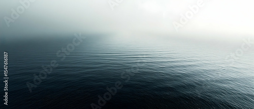Serene ocean view on a misty morning, showcasing a tranquil and calming seascape with subtle waves and a hazy horizon.