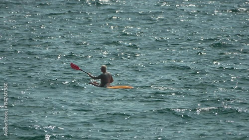 Kayaking Ocean Water Sport: A single person paddles a kayak on a choppy sea.