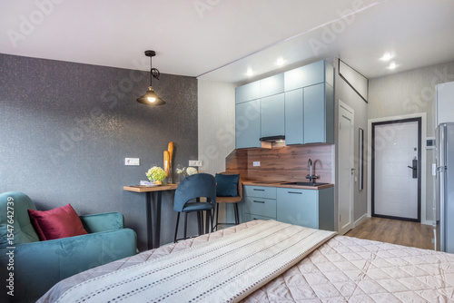 Bright and inviting studio apartment featuring a stylish kitchen, comfortable seating area, and contemporary decor. Ideal for relaxation or short stays in the city, filled with natural light.