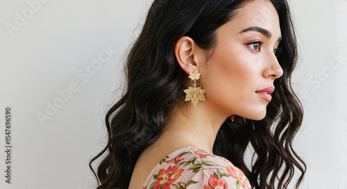 Young woman wearing maple leaf earrings and floral dress profile  