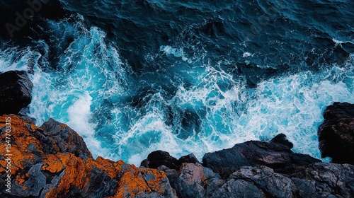 Ocean waves crashing against dark rocky cliffs vibrant turquoise water