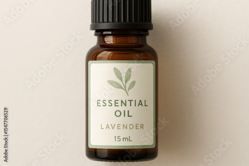 A brown glass bottle filled with lavender essential oil features a simple, elegant label displaying green leaves and product details on a light background