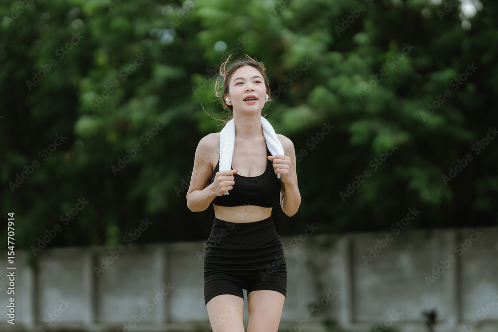 A fit and focused woman jogs outdoors in a serene green park, wearing activewear and earphones, embracing a healthy lifestyle, motivation, and self-care through exercise. A fit and focused woman jogs outdoors in a serene green park, wearing activewear and earphones, embracing a healthy lifestyle, motivation, and self-care through exercise.
