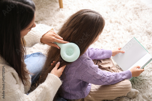 Young mother brushing hair ...