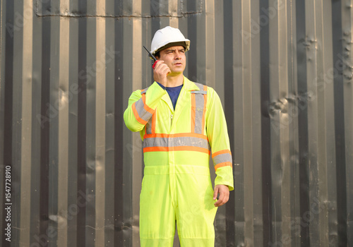 Worker or engineer using walkie talkie and talking about work in containers warehouse storage