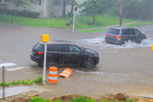 Obraz na plátně Vehicles struggle to navigate flooded streets during heavy rainstorm in residential neighborhood