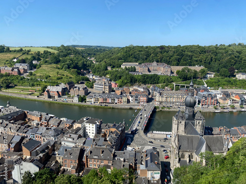 Aerial view of Dinant, Belgium, from the top of the citadel on a clear day, overlooking the Meuse River, cityscape, and surrounding landscape.
