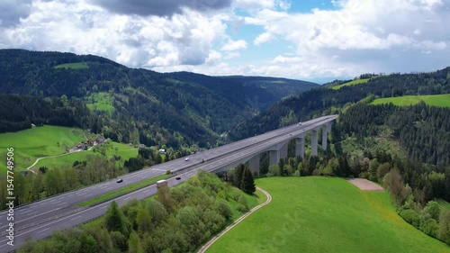 4k Aerial view of the autobahn, moving cars. Countryside summer road in Austria. Transportation cargo delivery. Tracking shot.
