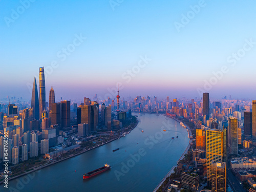 Aerial view of Shanghai skyline with winding river at sunrise.