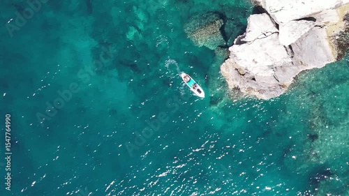 Aerial top down of couple on a kayak relaxing in the clear sea near the rocks. Croatia