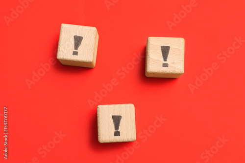 Wooden cubes with exclamation marks on red background