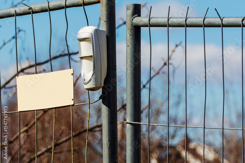 Wireless motion detector on a metal temporary fence