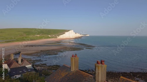 Drone glides past the white cliffs of Seven Sisters, revealing the Coastguard Cottages perfectly placed at a dramatic coastal edge