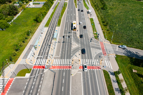 Obraz na plátně Major multilane road intersection with public bus stop and crosswalks in suburba