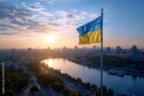 Ukraines flag waves over Kyiv with the Dnieper River and city skyline visible at sunrise