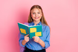 Happy schoolgirl holding a notebook with colorful sticky notes on a bright pink background, smiling and joyful