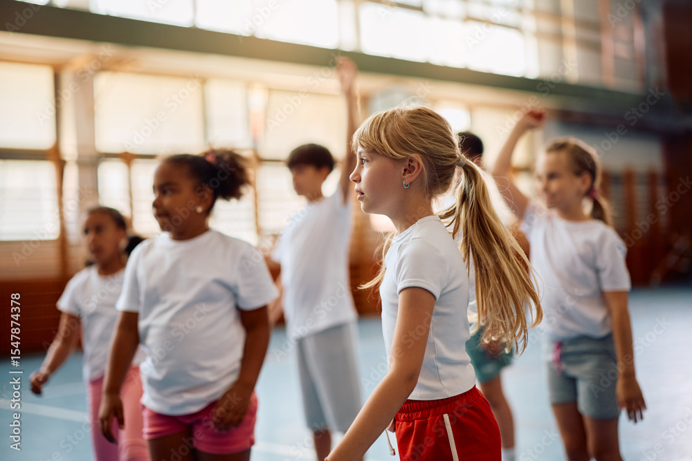 © Drazen - Little girl and and her classmates having physical education class at school gym. © Drazen - Little girl and and her classmates having physical education class at school gym.
