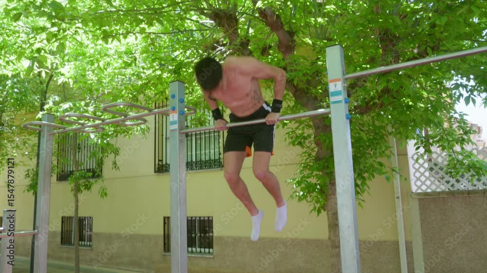 Young man performing calisthenics routine on horizontal bar