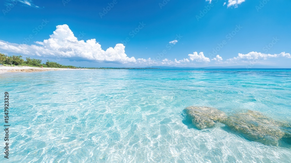 Obraz premium A serene beach scene with crystal clear water and fluffy clouds above. Perfect for relaxation and vacation imagery.