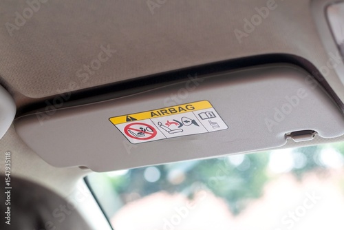 Bild auf Leinwand A sun visor in a car with airbag safety sticker label