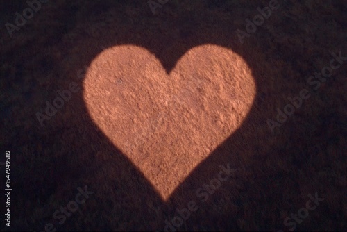 Heart-shaped shadow cast on grass surface demonstrating love and affection creating a visually engaging composition showcasing warmth and connection in natural surroundings