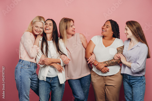 фотографія Five diverse women embracing and laughing together on pink background