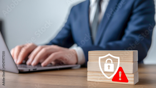 A professional business photograph showing a person in a dark navy suit typing on a laptop keyboard, partially visible in the background