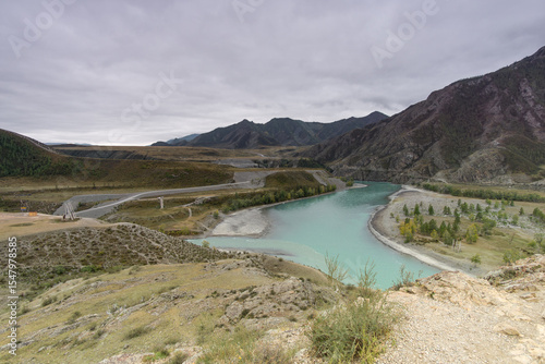 Wallpaper Mural Serene river winding through a mountainous landscape, with lush greenery along the banks, under a cloudy sky, showcasing the beauty of nature and tranquility in the wilderness Torontodigital.ca