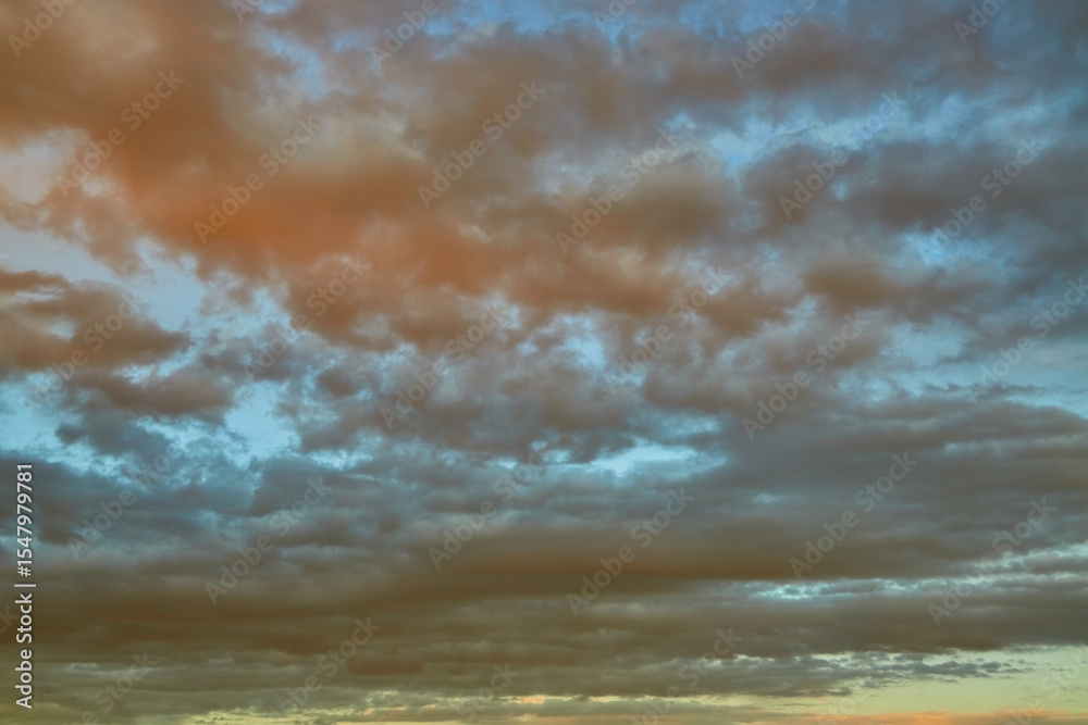 Obraz premium Thunderstorm clouds with golden edges in the rays of sunset. A symbol of contrast between strength and beauty.