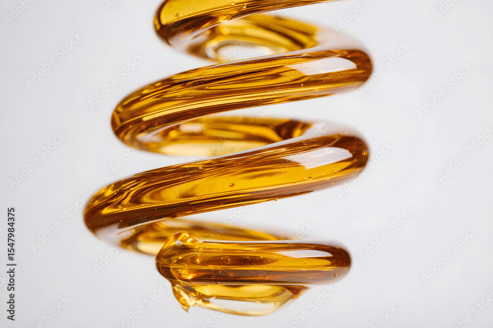 Fototapeta premium Spiraling stream of golden viscous liquid with transparent reflections.