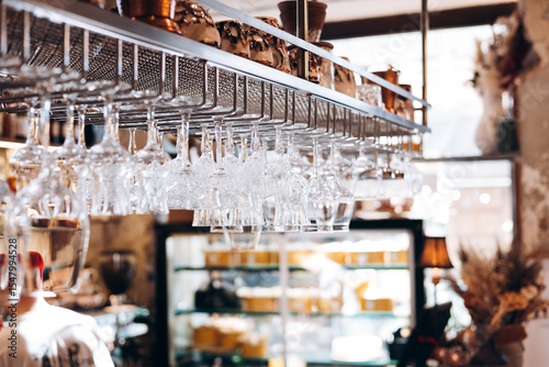 Glass wine glasses hanging at the bar in a cozy cafe, copy space.
