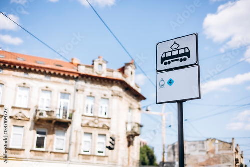 Tram stop sign in the city background, urban public transport symbol on street.