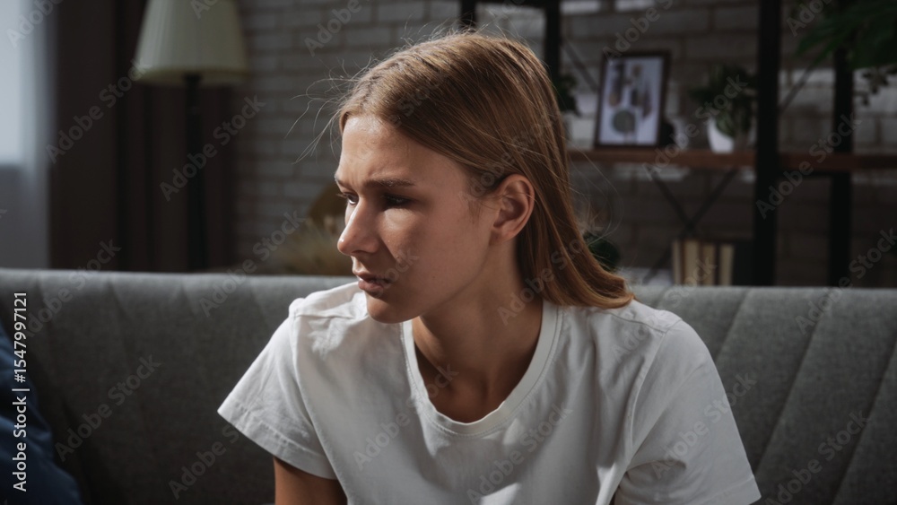 Young Woman in Thoughtful Pose on Comfortable Sofa Young Woman in Thoughtful Pose on Comfortable Sofa