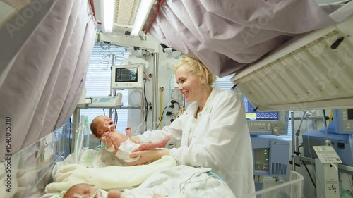 A nurse tending to premature infants in a neonatal intensive care unit (NICU). A medical professional holds a premature baby in a neonatal intensive care unit, surrounded by specialized equipment.