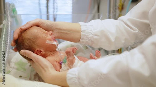 A premature baby receives medical care in a neonatal intensive care unit (NICU). A doctor is assisting the baby. Neonatal Intensive Care Unit