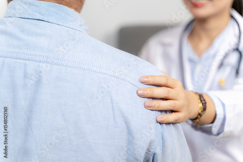 Compassionate doctor placing hand on patient’s shoulder, offering emotional support and encouragement.