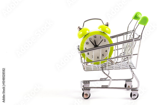Alarm clock in miniature supermarket shopping trolley on white background