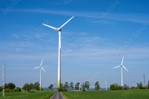 Modern wind turbines with a small country road seen in Germany