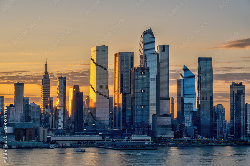 Fototapeta premium he skyline of Midtown Manhattan in New York with the famous Empire State Building with the first rays of sunshine of the day