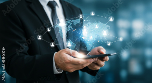 Global Network on Mobile: A businessman in a sleek suit holds a smartphone displaying a glowing world map connected by a complex network of nodes, symbolizing global connection and network expansion.