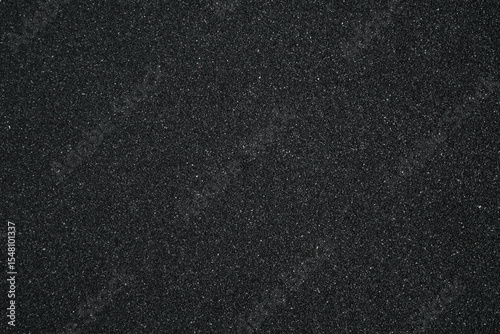 Black sand background. Beautiful creative natural background with visible little sand texture. Sand on the ground. Rough texture, construction material background