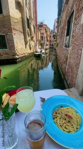 Venetian Lunch by the Canal: A vibrant scene of a delicious pasta dish and refreshing drink. Capturing the essence of a perfect meal.