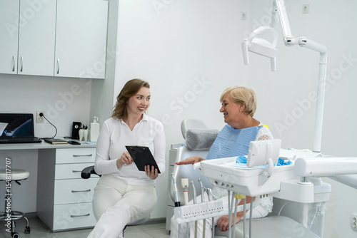 Pretty young mature woman sitting  during  
consulting with doctor at dental clinic. Health care concept