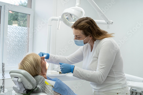 Senior female client having repairing tooth at dentist's office. Concept of ready for teeth cure