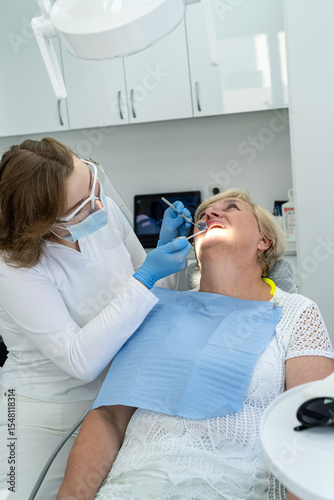 Senior female client having repairing tooth at dentist's office. Concept of ready for teeth cure