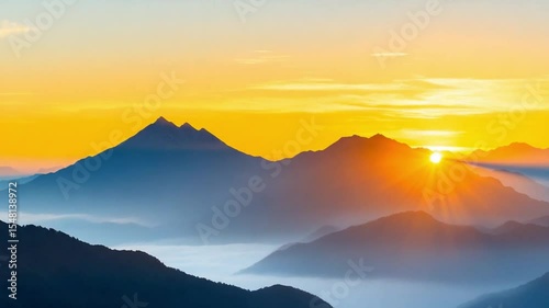 Majestic Sunrise Over Mountain Peaks: Warm sunlight bathes towering mountains, piercing through layers of soft mist in a serene landscape, capturing the essence of a tranquil sunrise.